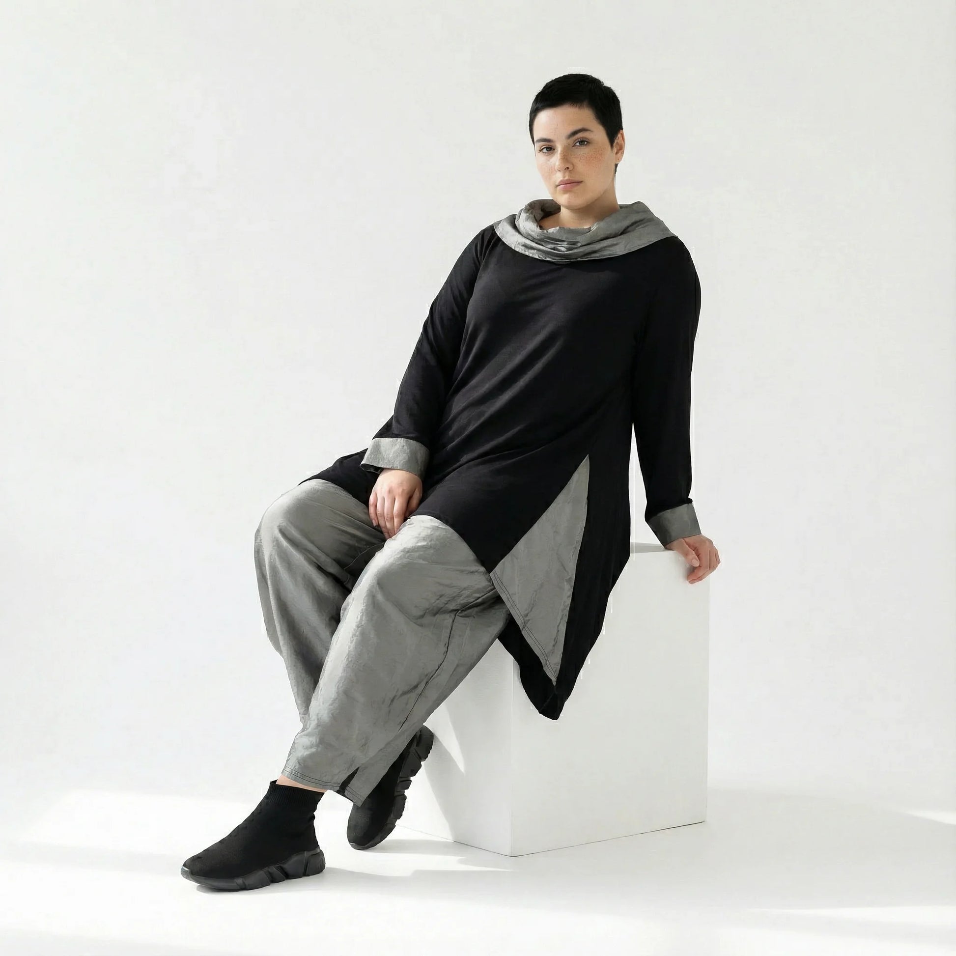 MODEARE - Asymmetrisches Oversize-Shirt in Schwarz mit Taftdetails und Nahttaschen – vorne kurz