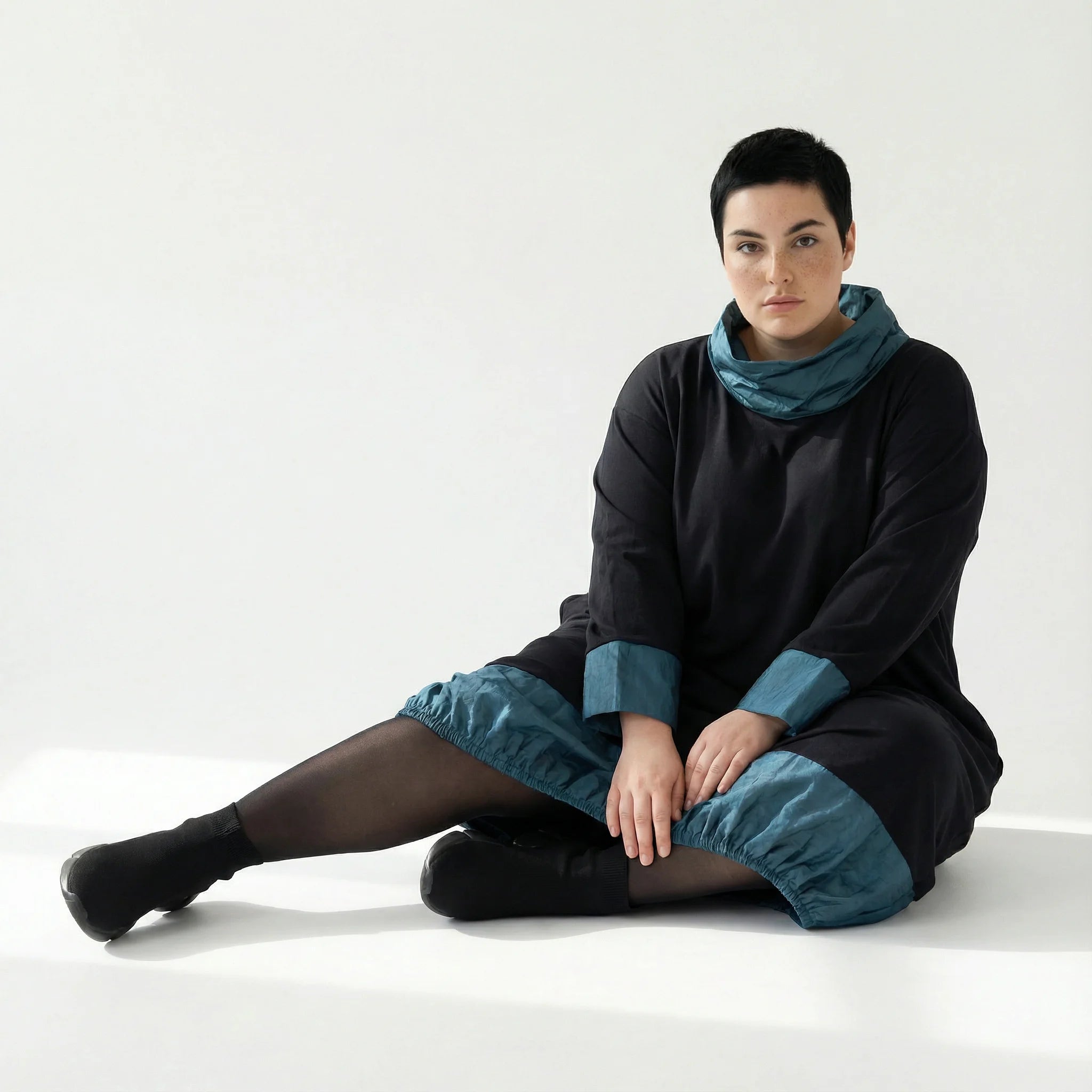 MODEARE - Oversize Ballonkleid mit Memorytaft-Details in Schwarz-Petrol und elastischer Raffung