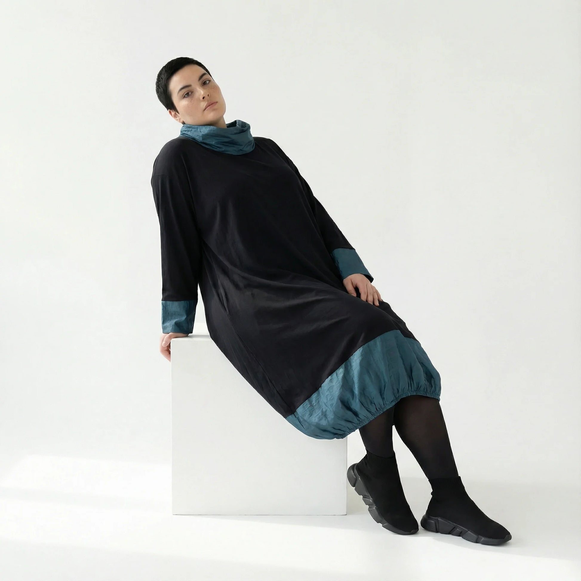 MODEARE - Oversize Ballonkleid mit Memorytaft-Details in Schwarz-Petrol und elastischer Raffung