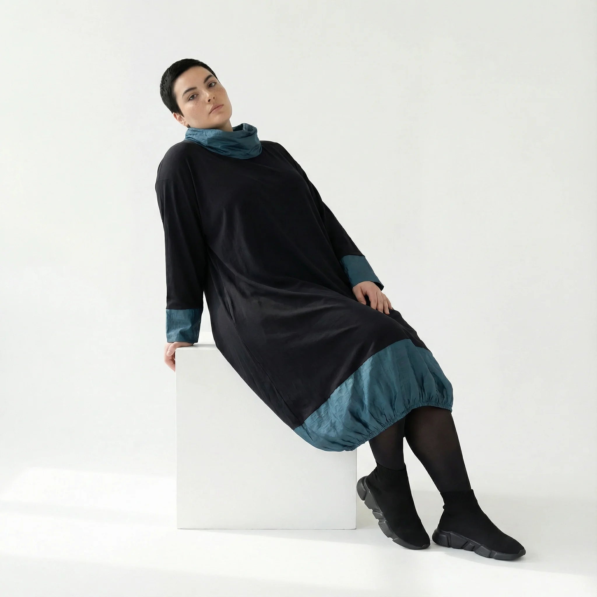 MODEARE - Oversize Ballonkleid mit Memorytaft-Details in Schwarz-Petrol und elastischer Raffung